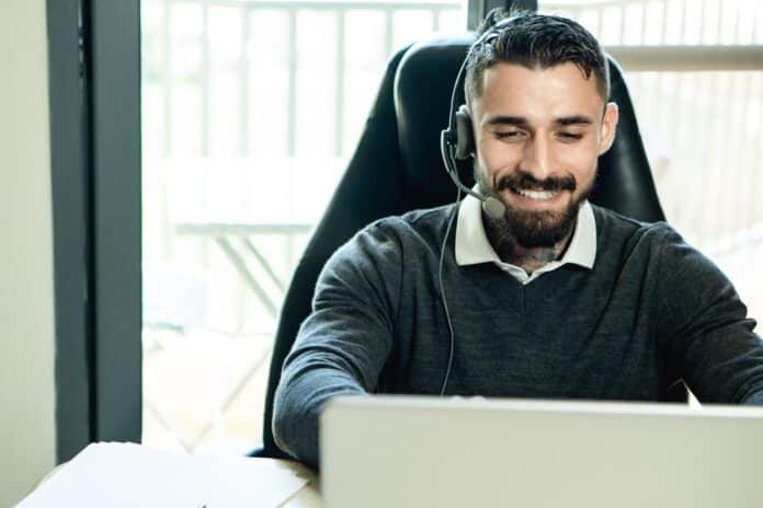 bearded man wearing headphones while working in the office